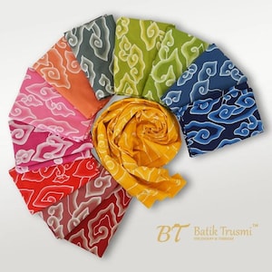 Könnte beinhalten: Eine Sammlung gefalteter Stoffmuster, die in einem kreisförmigen Fächer angeordnet sind und verschiedene Farben wie Gelb, Orange, Pink, Rot, Grün, Grau und Blau aufweisen, alle mit einem sich wiederholenden wolkenartigen Batikmuster. Der Text Batik Trusmi ist sichtbar.