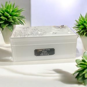 May include: White jewellery box with a silver butterfly design and a silver plaque that reads "Happy 50th Birthday Mum Lots of Love Hollie & Sam xx".