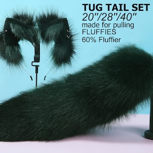May include: A set of three dark green faux fur tails in sizes 20 inches, 28 inches, and 40 inches. The tails are made for pulling and are 60% fluffier. The tails are displayed on a mannequin hand.