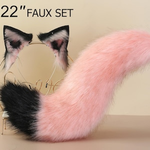 Könnte beinhalten: Ein rosa-schwarzer Kunstfellschwanz mit einem passenden Paar Ohren. Der Schwanz ist 56 cm lang und das Set ist mit "22" Faux Set" gekennzeichnet.
