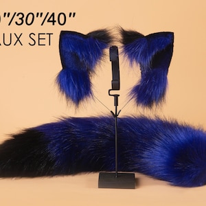 May include: A blue faux fur tail with a black tip, measuring 20", 30", or 40" in length. The tail is displayed with a matching set of blue faux fur cat ears with black tips.