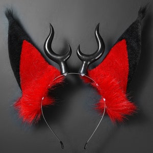 K&ouml;nnte beinhalten: Ein schwarzes Stirnband mit roten und schwarzen Fell-Ohren und schwarzen H&ouml;rnern. Das Stirnband ist f&uuml;r Cosplay oder Kost&uuml;mverwendung.