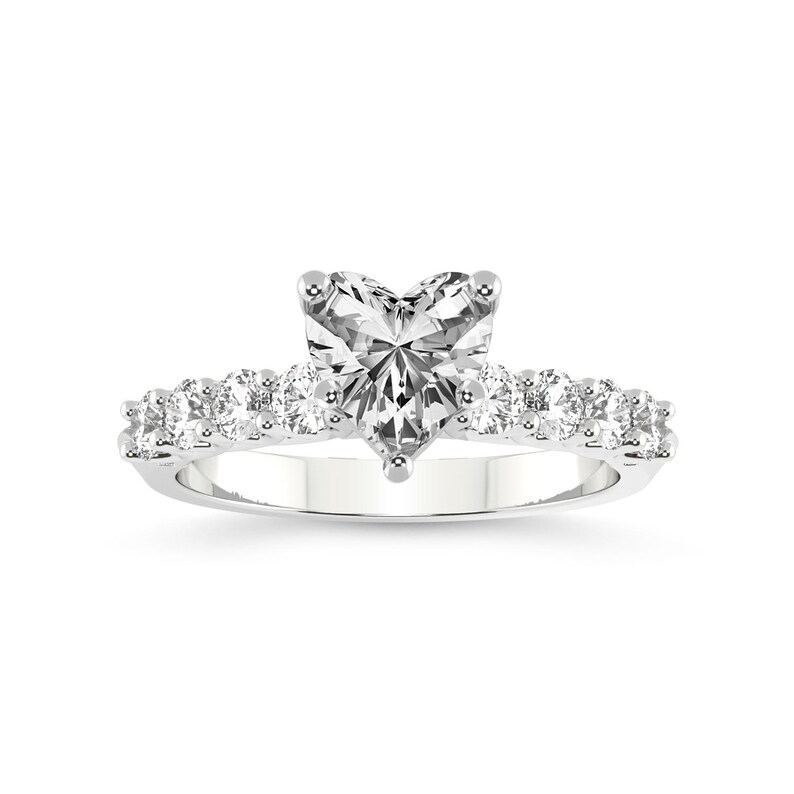 K&ouml;nnte beinhalten: Ein Verlobungsring aus Wei&szlig;gold mit einem herzf&ouml;rmigen Diamanten. Der Ring ist mit Pav&eacute;-Steinen besetzt und hat einen gro&szlig;en, herzf&ouml;rmigen Diamanten in der Mitte, der von kleineren Diamanten umgeben ist.
