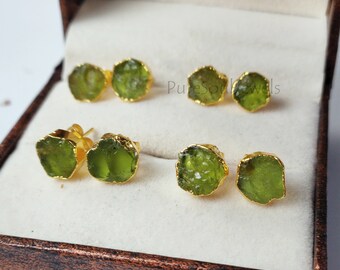 May include: Six pairs of green gemstone earrings with gold settings. The earrings are displayed in a white box with a brown lid. The text "PureSoulJewels" is visible on the box.