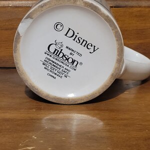 Puede incluir: Taza de cer&aacute;mica blanca con un dise&ntilde;o de personaje de Disney. La taza tiene un borde marr&oacute;n y un asa marr&oacute;n. La parte inferior de la taza tiene el texto "&copy; Disney" y "MARKETED BY Gibson&reg;", junto con la direcci&oacute;n del sitio web "www.gibsonusa.com". La taza es apta para lavavajillas y microondas, pero se calentar&aacute; en el microondas. Est&aacute; hecha en China.