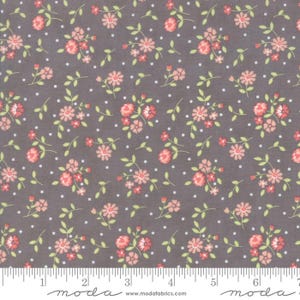 Könnte beinhalten: Stoff mit grauem Hintergrund, verziert mit rosa Blumenclustern und grünen Blättern. Kleine weiße Tupfen sind über das Design verstreut. Ein Lineal befindet sich am unteren Rand mit dem Wort "moda" aufgedruckt.