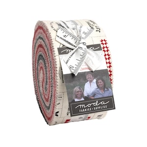 May include: A rolled bundle of fabric strips in shades of red, gray, and cream. The fabric is tied with a white ribbon and a tag featuring the Moda Fabrics logo and images of women. The fabric is printed with text and ruler markings.