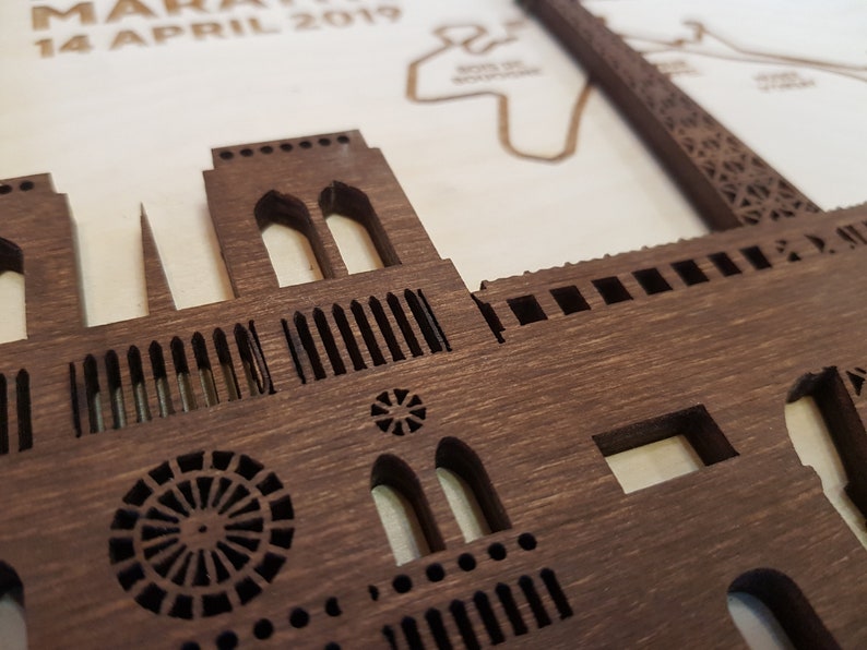 May include: A close-up of a wooden model of the Notre Dame Cathedral in Paris, France. The model is intricately detailed, with visible windows, arches, and a circular rose window.