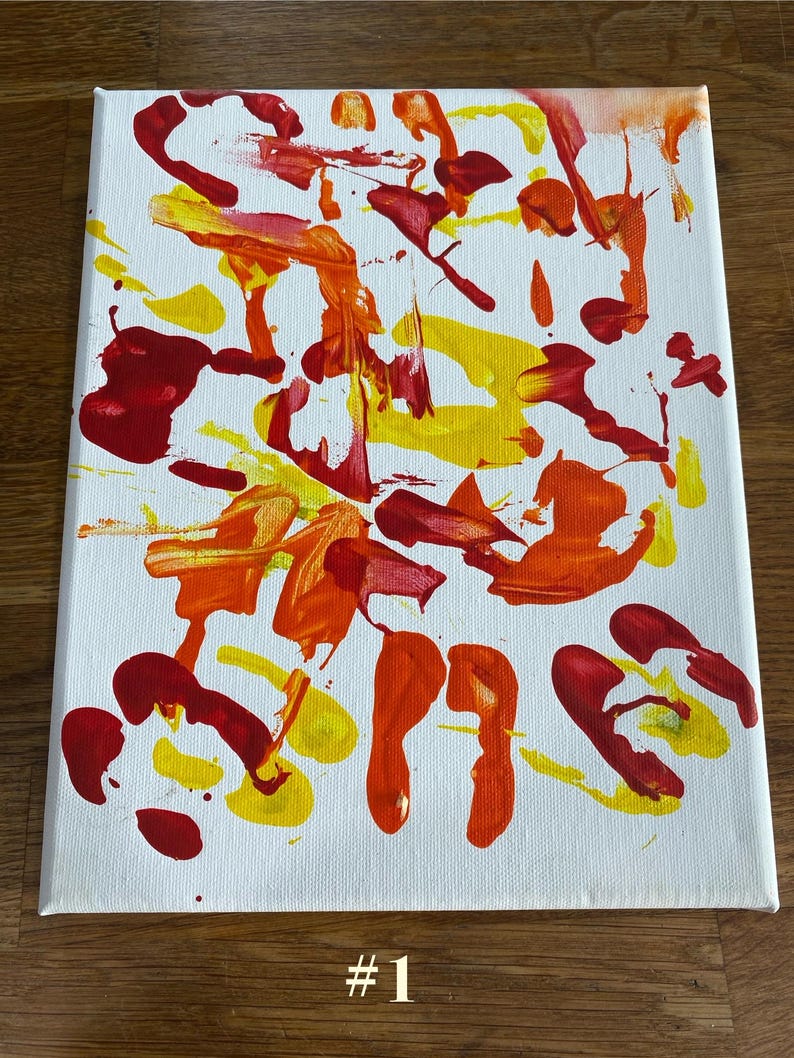Op de afbeelding: Abstract schilderij op een wit canvas met gedurfde streken van rode, gele en oranje verf. Het kunstwerk toont een verscheidenheid aan vormen en texturen, met het nummer "#1" in zwart onderaan.