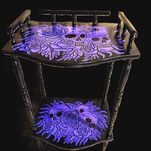 Table de téléphone vintage en bois, un meuble riche en détails et orné d'un motif de crâne peint à la main.