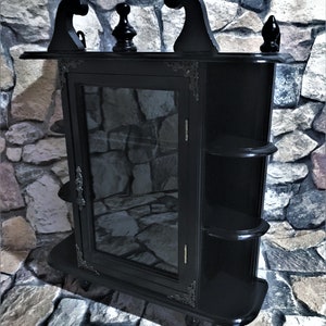 Gothic wooden display cabinet, a small, very special piece of furniture in elegant black with a glass door