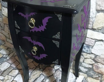 Comodino in legno con due cassetti, un mobile vintage dalla forma elegante e decorato con pipistrelli