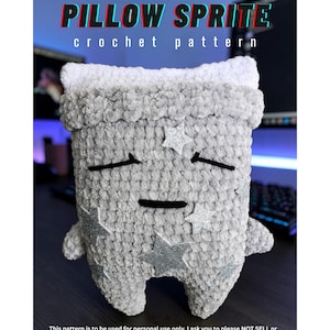 Op de afbeelding: Een grijs en wit gehaakt knuffeltje in de vorm van een kussen met een slapend gezicht en zilveren glitterster-applicaties. De tekst PILLOW SPRITE crochet pattern staat bovenaan, met gebruiksinstructies onderaan de afbeelding.