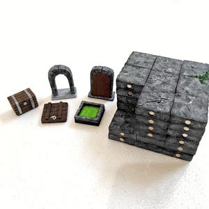 Puede incluir: Una colección de piezas de terreno para juegos de mesa en miniatura que incluye un cofre de madera marrón, un arco de piedra, una puerta de madera, una baldosa de madera, un foso cuadrado de líquido verde y bloques de muro de piedra gris con imanes.