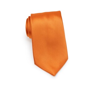 May include: A solid orange satin necktie. The tie is rolled up and the tip is pointed.
