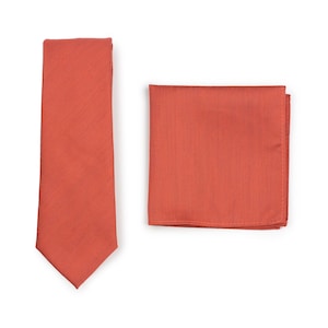 May include: A set of two orange-red accessories, a tie and a pocket square. Both are made of a textured fabric.