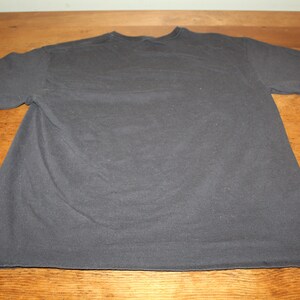 May include: A plain dark grey t-shirt with short sleeves.