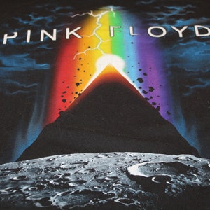May include: Black t-shirt featuring a graphic of a mountain, a rainbow, and the text "PINK FLOYD".