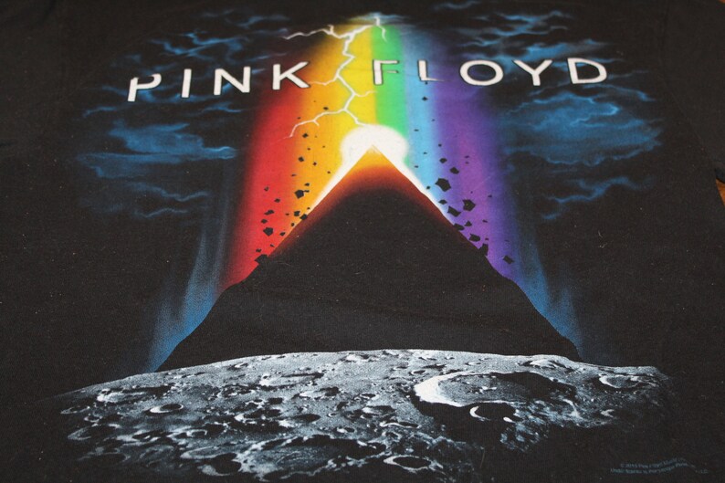 May include: Black t-shirt featuring a graphic of a mountain, a rainbow, and the text "PINK FLOYD".