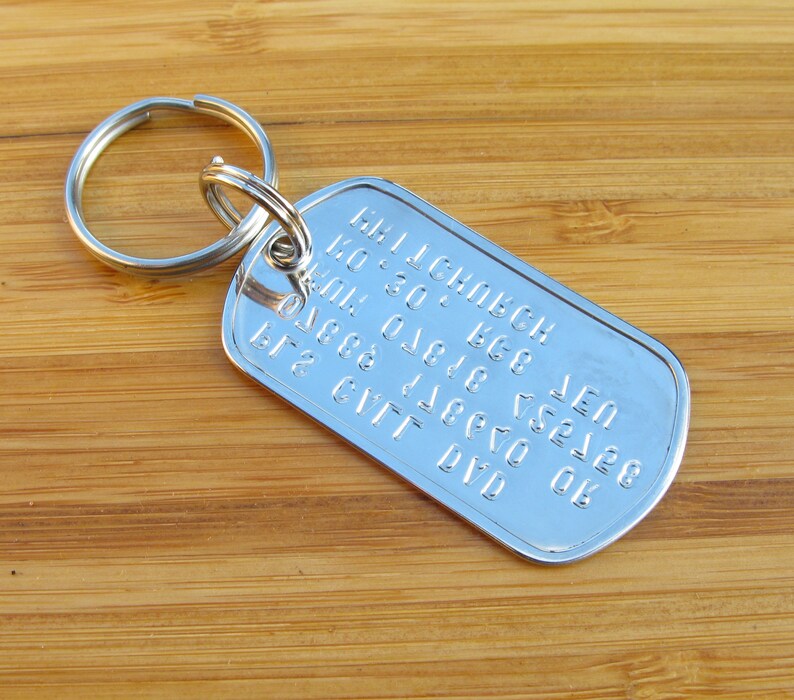 May include: Silver keychain with a dog tag featuring the text "MILLENBECK  LEN  K0 30  K68  01 0 018  7528  08  6777  DYO".