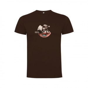 Puede incluir: Una camiseta marr&oacute;n con un gr&aacute;fico de un astronauta de pie en un planeta rojo con un rover y el texto "Another Paradise Found".
