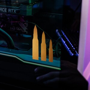 May include: A black computer tower with a clear side panel, showcasing internal components like fans, a graphics card, and a CPU cooler. The components are illuminated with blue and green lighting. Gold bullet icons are on the side.