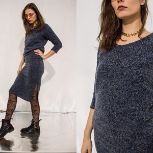 Puede incluir: Un suéter azul peludo con cuello redondo y mangas largas. El suéter está hecho de una tela suave y texturizada.