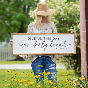 May include: A handmade wooden sign with the text "Welcome" in a playful font. The sign is painted white with a distressed finish, and features a decorative floral design in shades of pink and green. It measures approximately 12 inches wide.