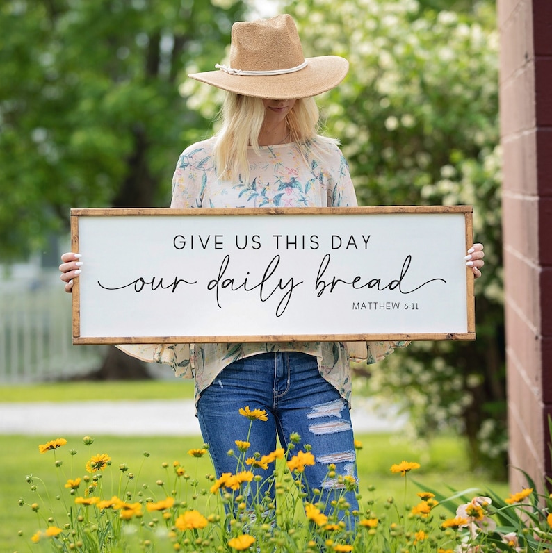 May include: A handmade wooden sign with the text "Welcome" in a playful font. The sign is painted white with a distressed finish, and features a decorative floral design in shades of pink and green. It measures approximately 12 inches wide.