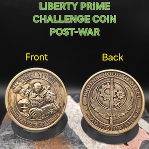 May include: A bronze Liberty Prime challenge coin with the text "Liberty Prime Challenge Coin Post-War". The front of the coin features a detailed image of a robot and the words "Democracy is Non-Negotiable". The back says "Brotherhood of Steel".