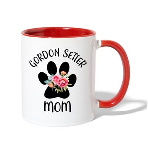 Puede incluir: Taza de caf&eacute; de cer&aacute;mica blanca con borde y asa rojos. La taza tiene una huella de pata negra con flores rosas y el texto "Gordon Setter Mom" impreso en ella.