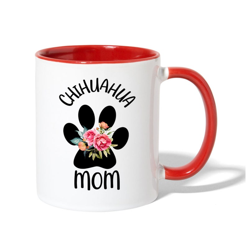 May include: White ceramic coffee mug with a red rim and handle. The mug has a black paw print with pink flowers and the text "Chihuahua Mom" printed on it.