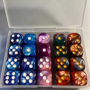 May include: A clear plastic case containing sixteen multi-colored dice. The dice are various shades of blue, purple, green, and red with white or gold pips. The dice are arranged in four rows of four.