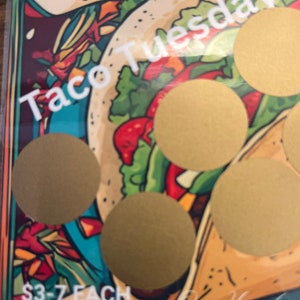 May include: A colorful illustration of a taco with gold circles covering the image. The text "Taco Tuesday" is at the top of the image and the text "$3-7 EACH" is at the bottom of the image.