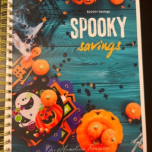 May include: A teal blue wooden background with a variety of Halloween decorations, including pumpkins, ghosts, and candy corn. The text "SPOOKY savings" is written in white with a black outline. The text "$1000+ Savings" is written in white with a black outline. The text "Our Hometown Treasures" is written in white with a black outline.