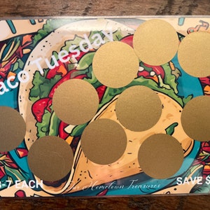 May include: A colorful card with a cartoon taco design. The card has eight gold circles with a scratch-off coating. The text on the card reads "Taco Tuesday", "$3-7 EACH", "Our Hometown Treasures", and "SAVE $40".