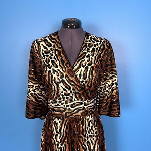 Puede incluir: Un vestido de envoltura de estampado de leopardo marr&oacute;n y crema con cuello en V y mangas 3/4.