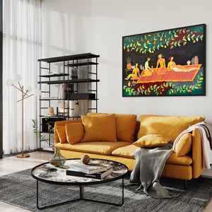 May include: A living room interior with a mustard yellow sofa, a black metal coffee table, a black metal shelving unit, and a framed painting of people on a picnic blanket. The painting is in a black frame and has a colorful abstract style.