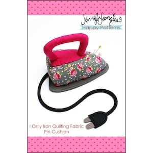 May include: A gray and pink iron-shaped pin cushion with a floral print and a black cord. The text "I Only Iron Quilting Fabric Pin Cushion" is printed below the cushion.
