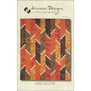 May include: Quilt pattern design titled "Fire Escape" by Atkinson Designs. The pattern features a geometric design with a mix of orange, red, brown, and cream colors.