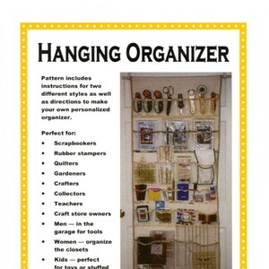 May include: A beige door with a hanging organizer made of fabric and rope. The organizer has multiple pockets and is filled with various items, including scissors, rulers, and other craft supplies. The text "Display and store all your tools and supplies on the back of a door!" is printed below the image.
