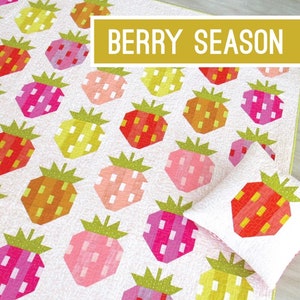May include: A quilt and pillow pattern featuring a patchwork design of strawberries in various shades of pink, red, orange, and yellow. The pattern is titled "Berry Season" and is by Elizabeth Hartman.