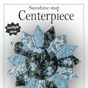 May include: A digital download pattern for a sunshine mat centerpiece. The pattern includes instructions for making a 28 inch or 18 inch centerpiece. The image shows a finished centerpiece with a floral design in shades of blue and green.
