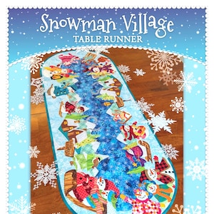 May include: A blue and white table runner with a snowman village design. The runner features snowmen, houses, and trees. The text "Snowman Village Table Runner" is printed on the top of the runner.