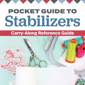 May include: A white guide book with the title "Pocket Guide to Stabilizers" and the subtitle "Carry-Along Reference Guide". The book is open to a blank page with the author's name, "Sue O'Very-Pruitt", printed at the bottom. The book is lying on a light blue fabric with embroidery designs and sewing tools.