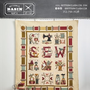 May include: A quilt pattern for a "Thimble Blossoms BOM" quilt featuring a colorful patchwork design with a central motif of the word "SEW" surrounded by sewing-themed images. The quilt measures 56 inches by 68 inches.