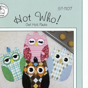 May include: A sewing pattern for three owl-shaped hot pads. The owls are made of different patterned fabrics in pink, green, blue, and brown. The pattern is titled "Hot Who! Owl Hot Pads" and is from Susie C Shore Designs.
