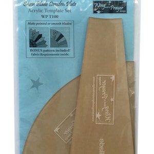 May include: A set of two acrylic templates for making a seven-blade Dresden plate. The templates are brown and have the text "Wing and a Prayer" and "Blade" printed on them. The packaging is blue and has the text "Seven Blade Dresden Plate Acrylic Template Set WP T100 Make pointed or smooth blades! BONUS pattern included! Fabric Requirements inside."