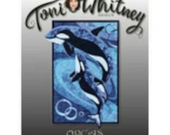 May include: A rectangular quilt pattern cover featuring the text Toni Whitney Design at the top and Orcas at the bottom. The central image displays two black and white orcas swimming through blue, patterned water with circular bubbles.