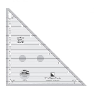 May include: A clear plastic 45° Half-Square Triangle ruler with markings in inches. The ruler has a black and white logo that says "Creative Grids" and the text "45° Half-Square Triangle Designed by Rachel Cross".